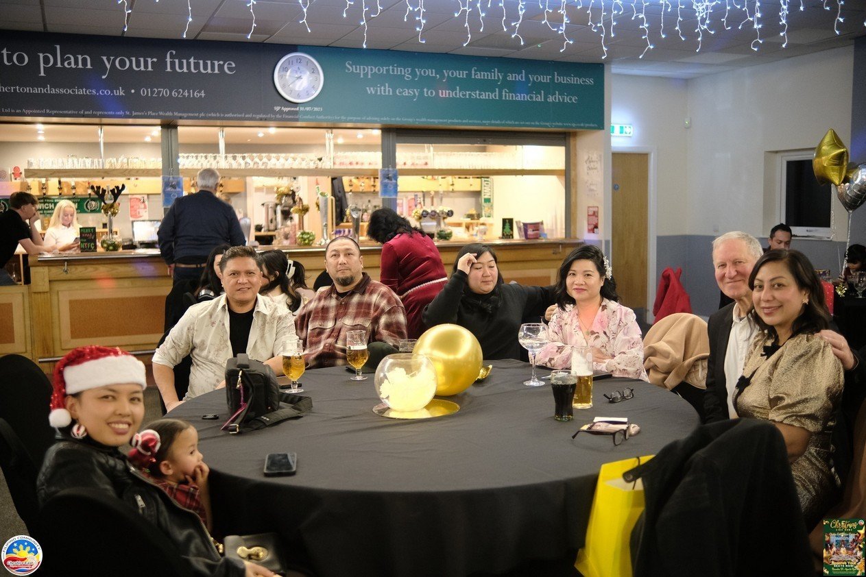 Friends smiling together around a table at Christmas